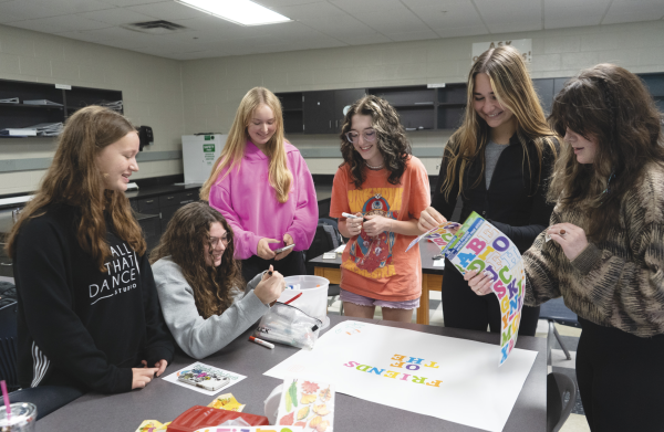 Members of Friends of the Earth make a poster for their table at club fair on Oct. 6. Sarah Davis (9), Macken- zie Burkhart (11), Ella Siwiec (9), Stella Decker (11), Melissa Holtby (12) and Fiona Pearce (11) advocate for composting and other sustainability efforts to protect the environment.
