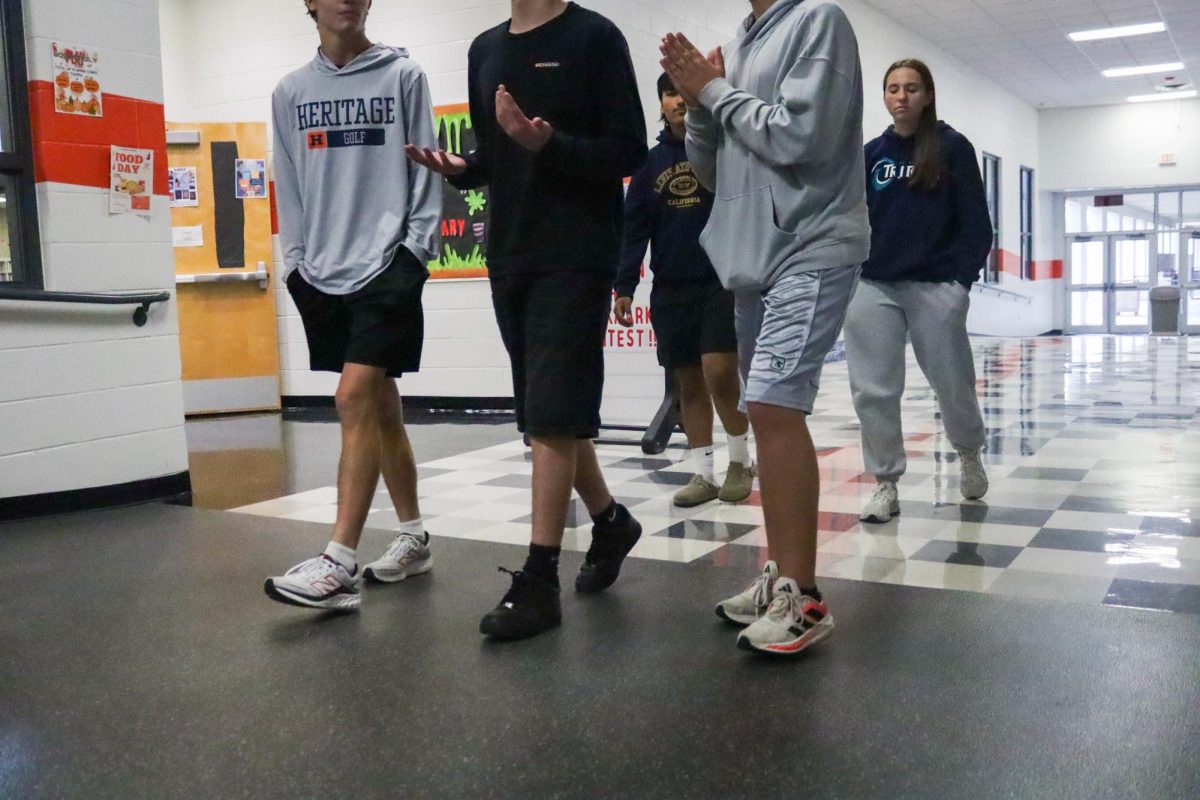 Students fall behind a group of slow walkers during passing period.