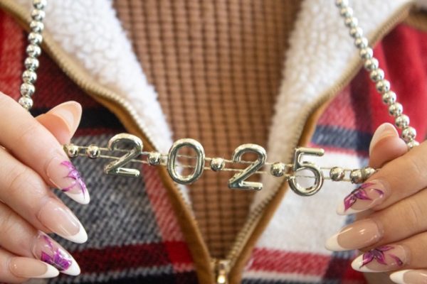 A student photographed holding a necklace that reads ‘2025’ from New Years celebration.