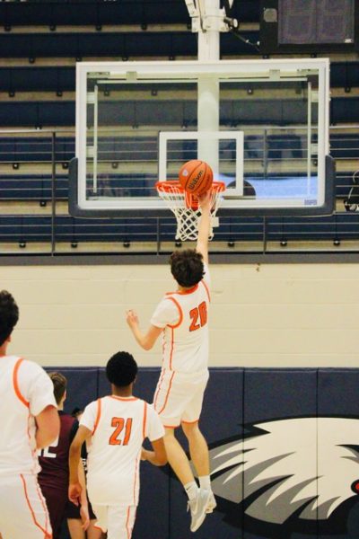 Heritage boys basketball students attempts and completes a basket.