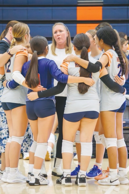 Volleyball team huddles up during a time out as Coach Sharon Felker instructs the team on how to better play during the set.