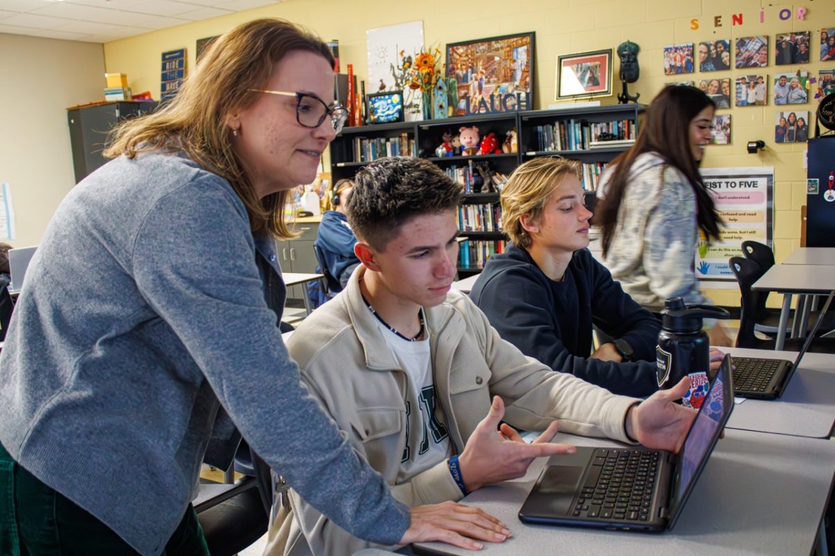 College Composition teacher coming to the aid of a student for a class assignment.