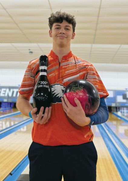 Parker Logan geared with an award he won after bowling a perfect score during a tournament against Russellville and
Gentry.
