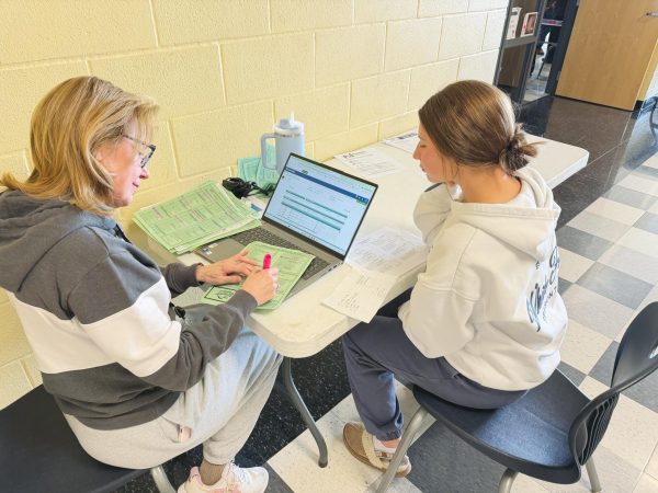 A counseler helping a student with class registration for the next school year.